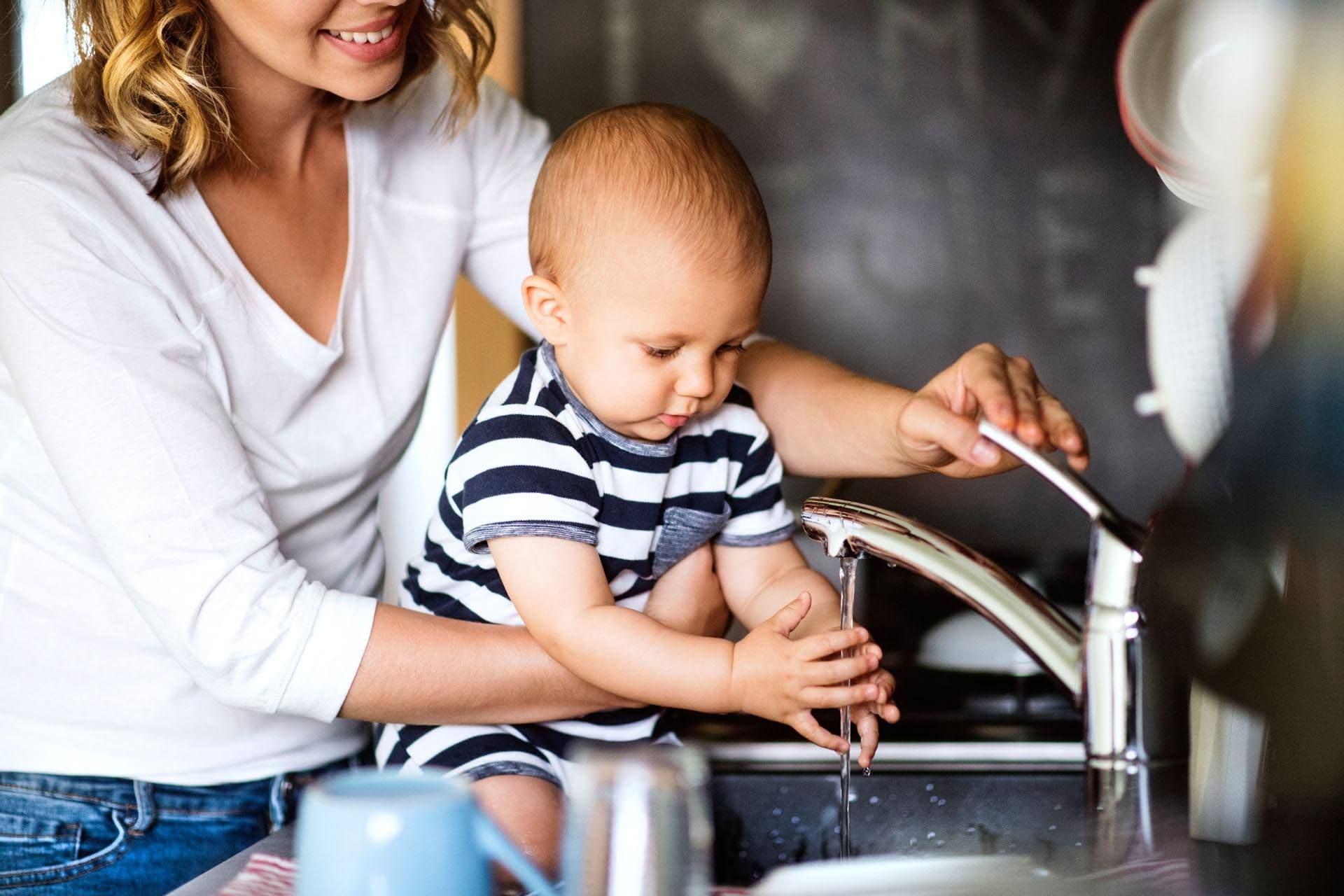 baby washing hands in sink